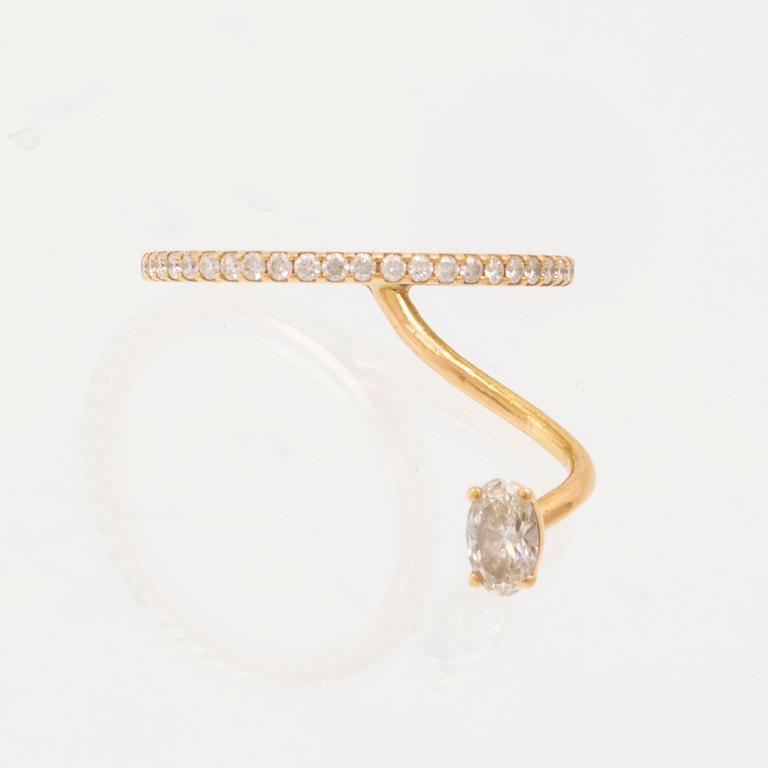 An 18K gold ring set with an oval cut and round brilliant cut diamonds by LWL Jewelry.