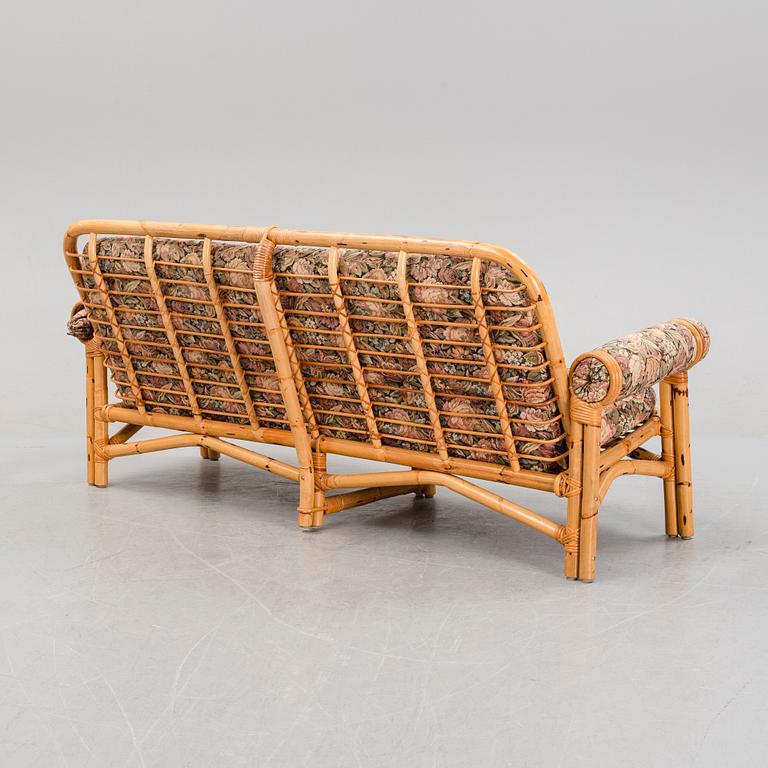 A set of two garden sofas, an armchair and a glass table, later part of the 20th Century.