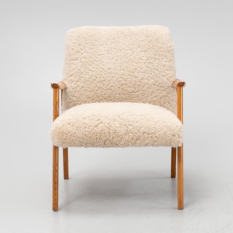 An oak easy chair with sheepskin upholstery. second part of the 20th Century.