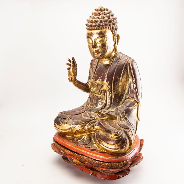 A large gilt and lacquered figure of a seated buddha, Qing dynasty, 19th Century.