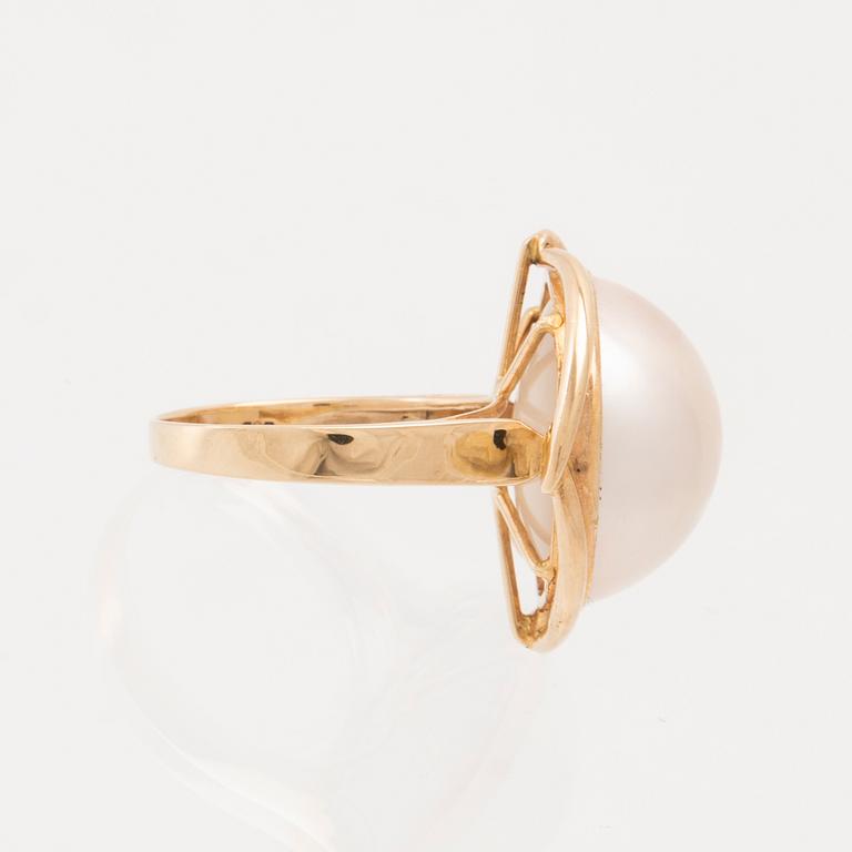 A 14K gold ring set with a cultured mabé pearl.