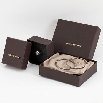 BOTTEGA VENETA, a pair of silver earrings and a silver ring.