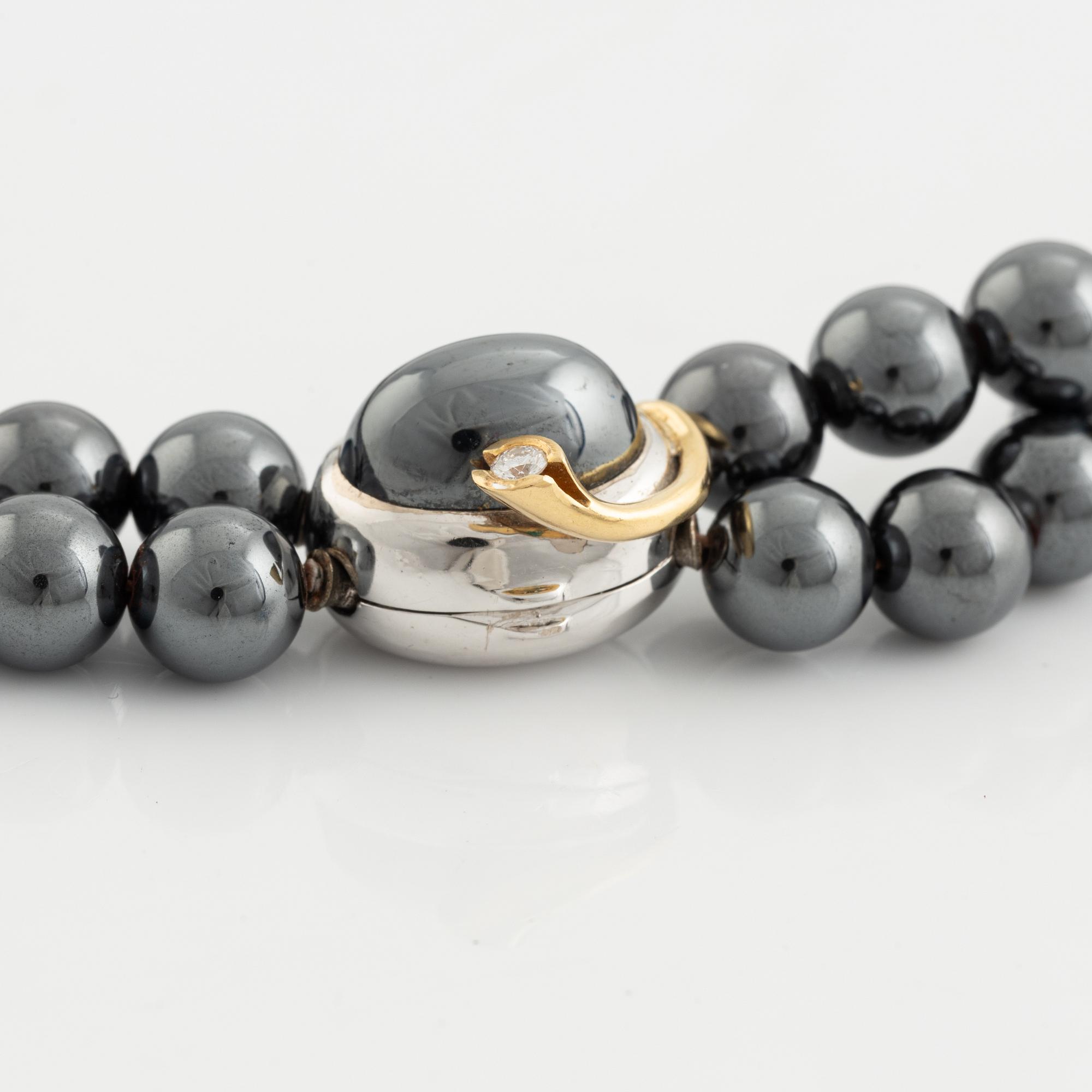 Ole Lynggaard. 2 rows of hematite beads with a clasp in 14K white gold and gold with a brilliant-cut diamond.