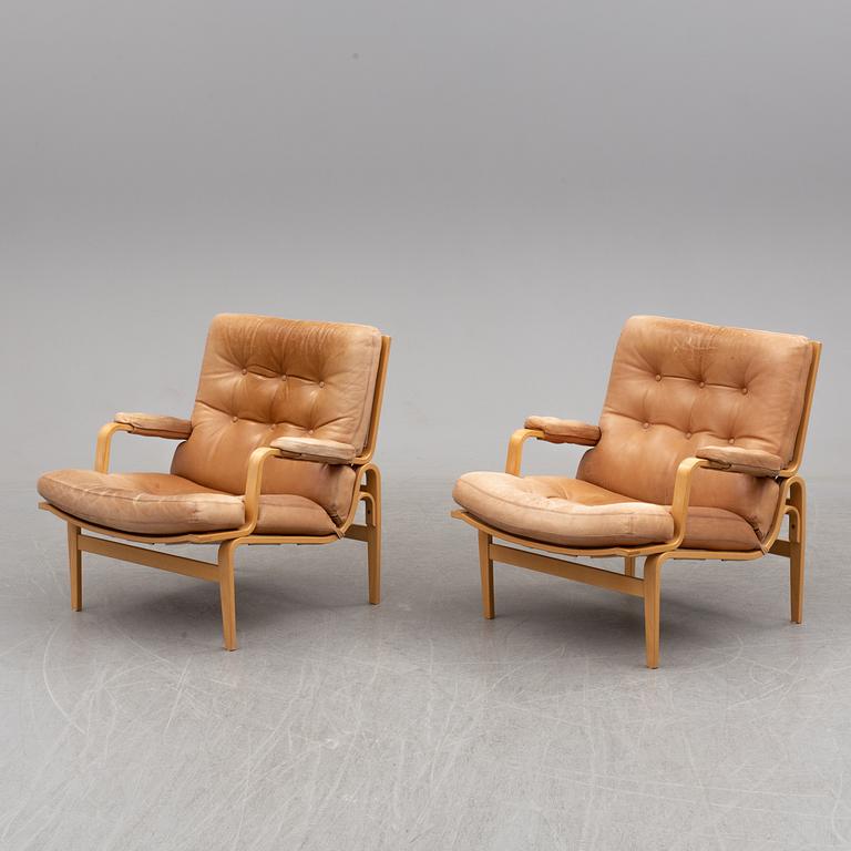 BRUNO MATHSSON, a pair of easy chairs with one stool.