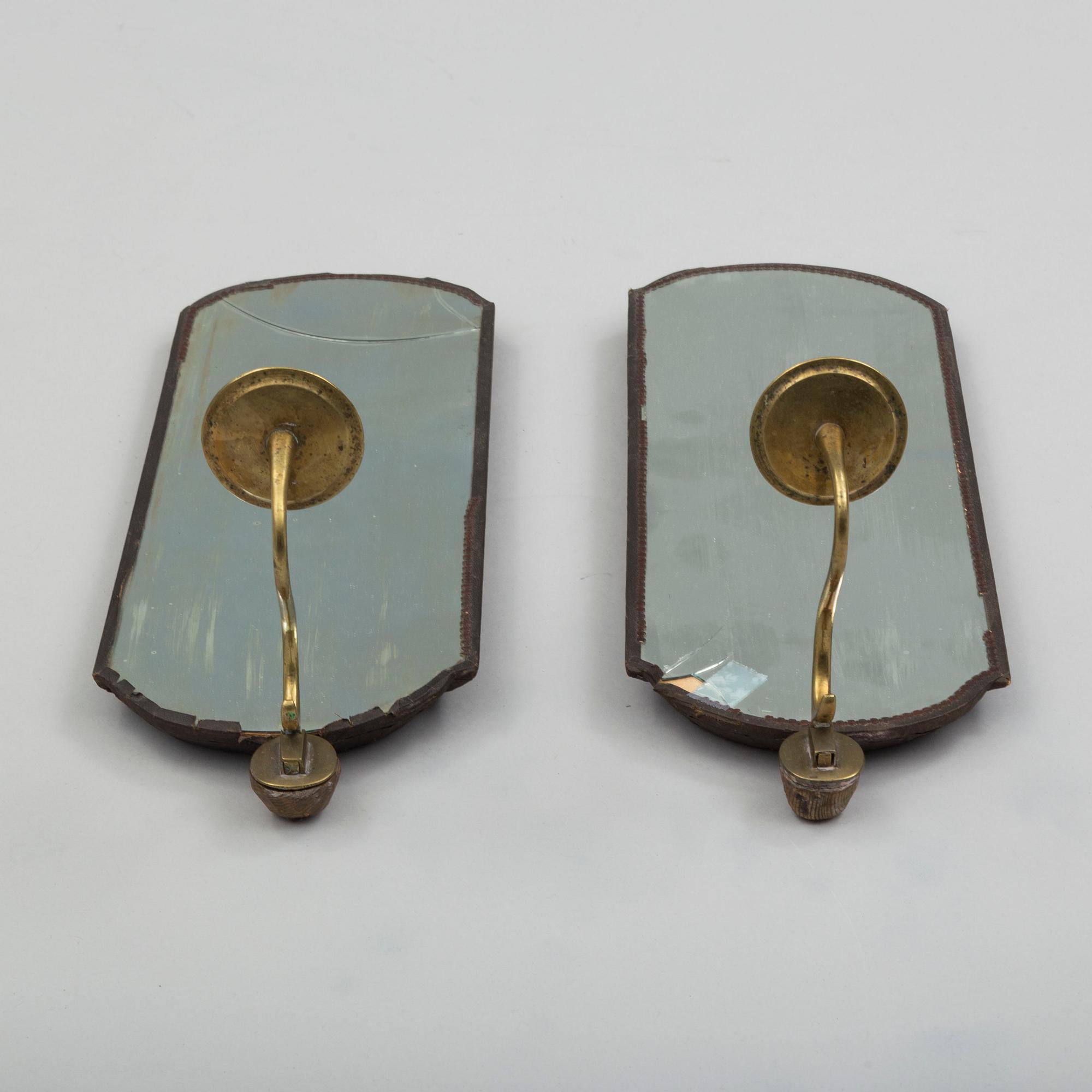 A pair of mirrors with candle sconces, partly 18th century.