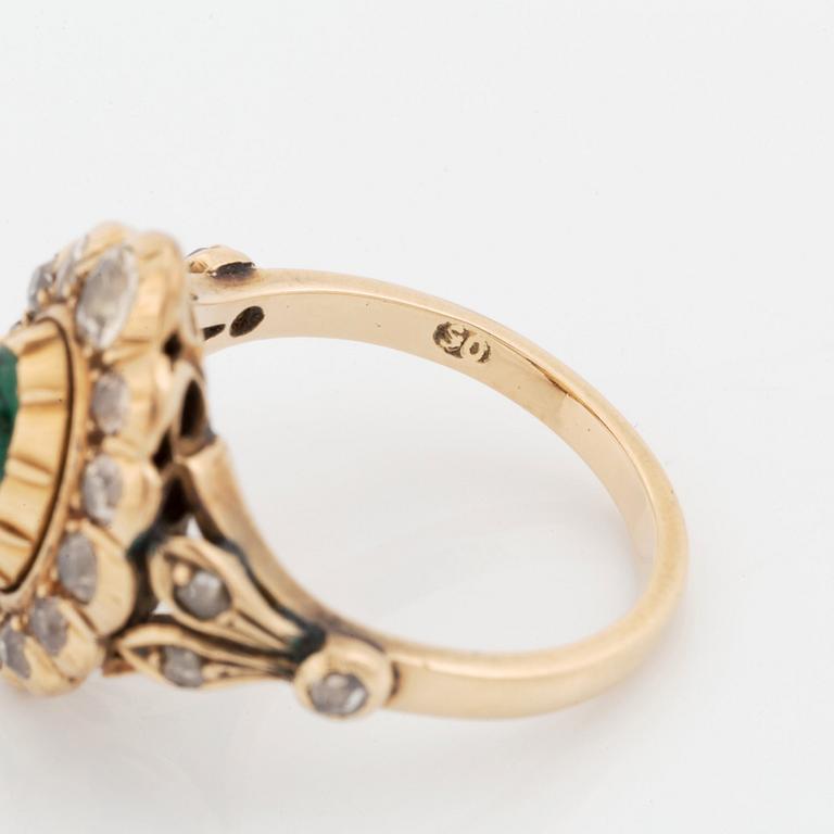 A 14K gold ring set with a cabochon-cut emerald and old-cut diamonds.