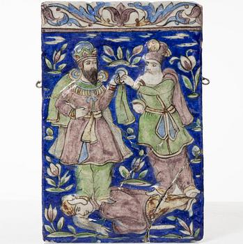 A Qajar moulded figural pottery tile, ca 26 x 19 cm.