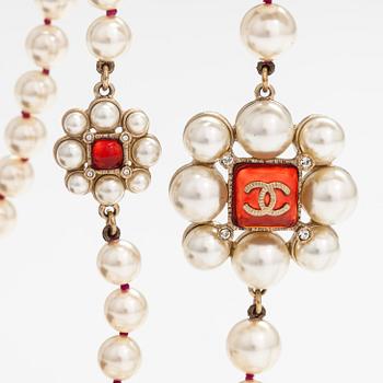 Chanel, A pearl collier with plastic pearls, glass stones and gold coloured metal parts. Marked Chanel, Made in France.