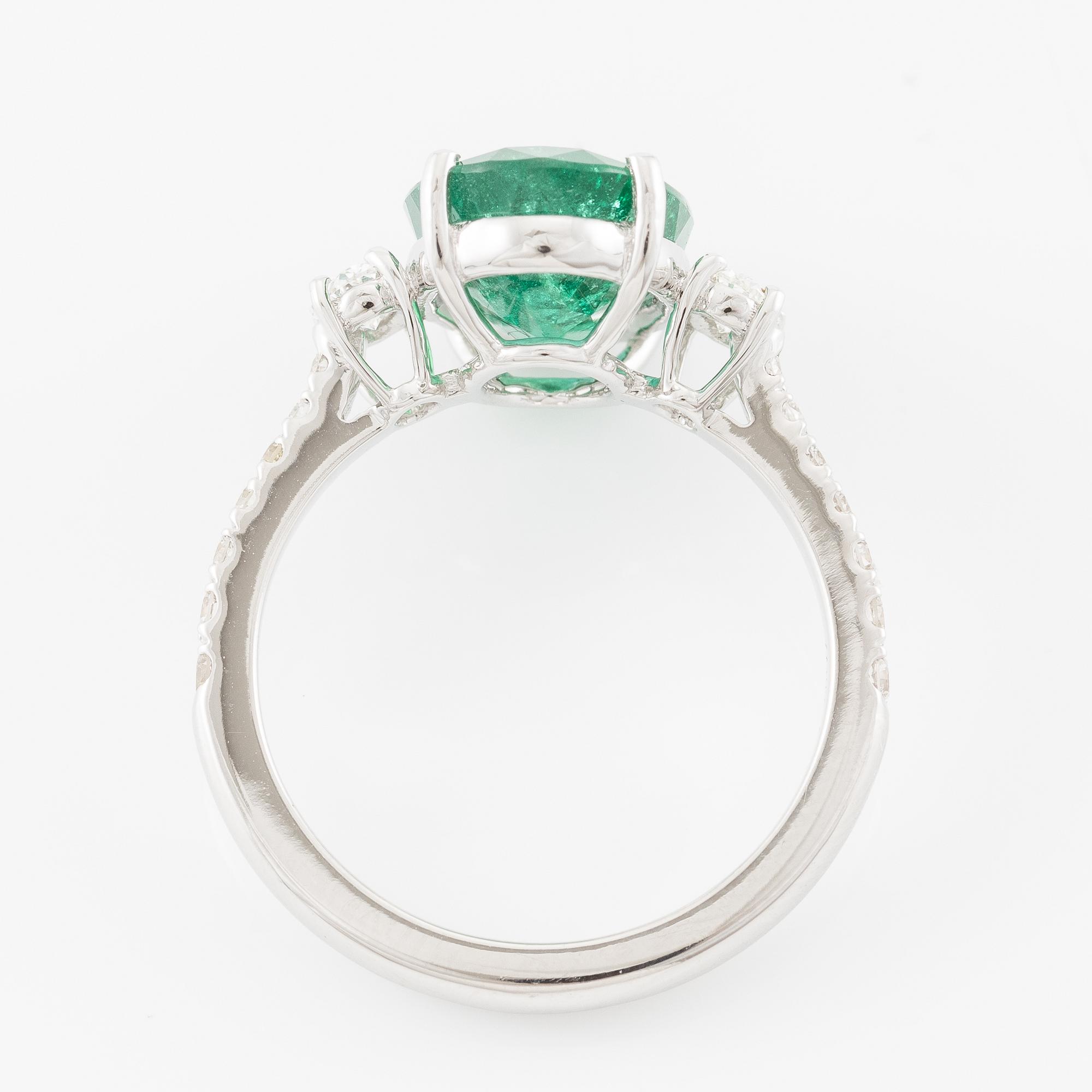 Ring in 18K white gold with an oval emerald and oval-cut and brilliant-cut diamonds.