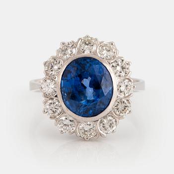 1020. An 18K white gold ring set with a faceted sapphire and round brilliant-cut diamonds.