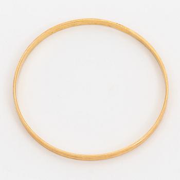 A bangle with a textured surface. 14K gold.