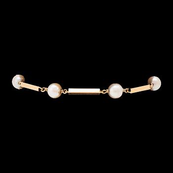 An 18K gold bracelet set with cultured pearls.