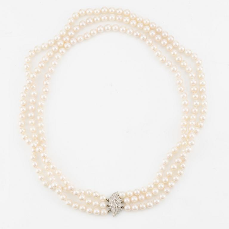 Necklace, pearls, three strands, clasp in 14K white gold with small diamonds.