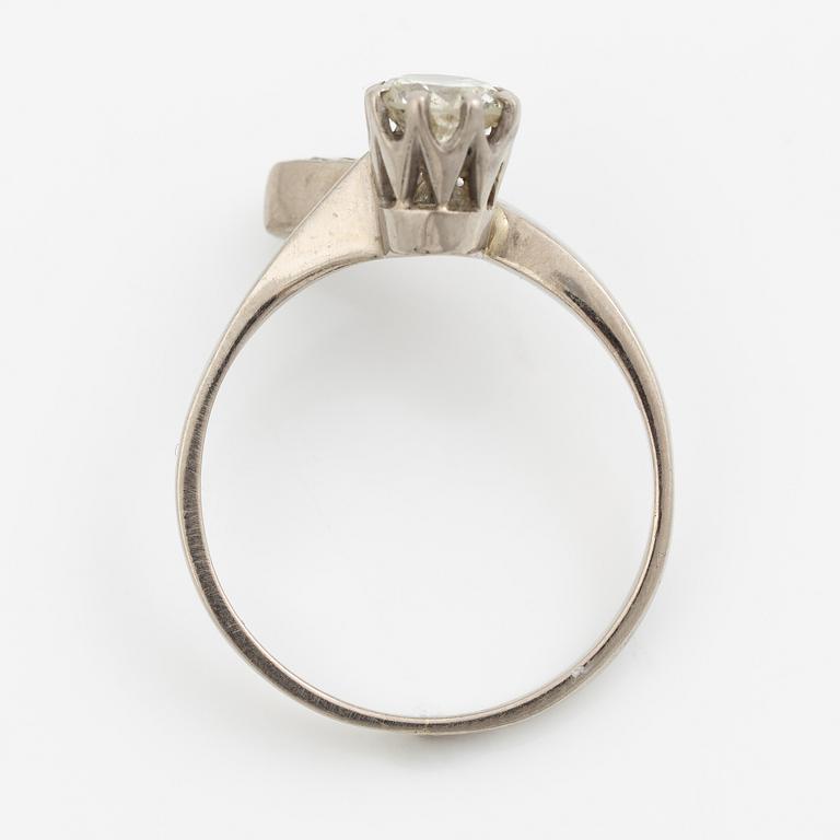 Ring, 18K vitguld med en briljantslipad diamant och  tre mindre briljantslipade diamanter.