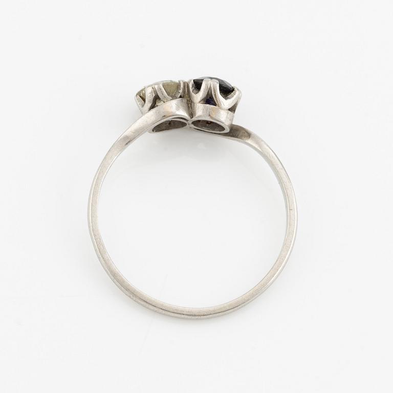 Ring, sibling ring, platinum with brilliant-cut diamond and dark sapphire.