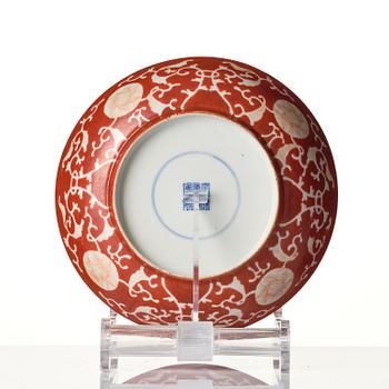 A coral-red reverse decorated dish, Qing dynasty with Guangxu mark and of the period (1875-1908).