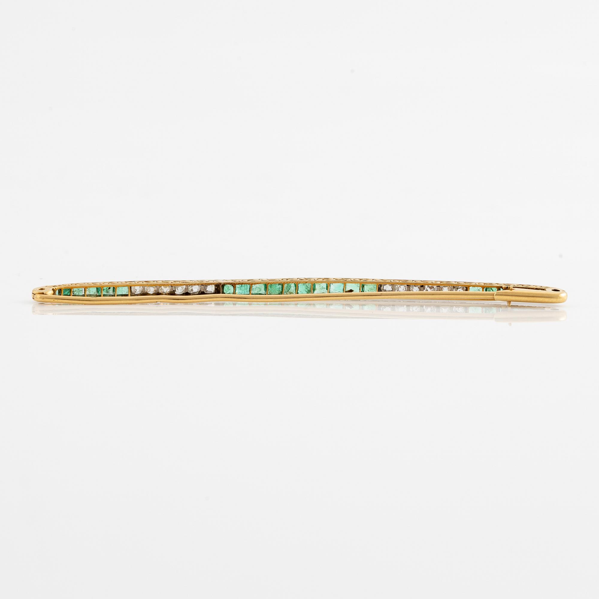 Brosch, längre modell, guld med carréslipade smaragder och gammalslipade diamanter, troligen omkring sekelskiftet 1900.