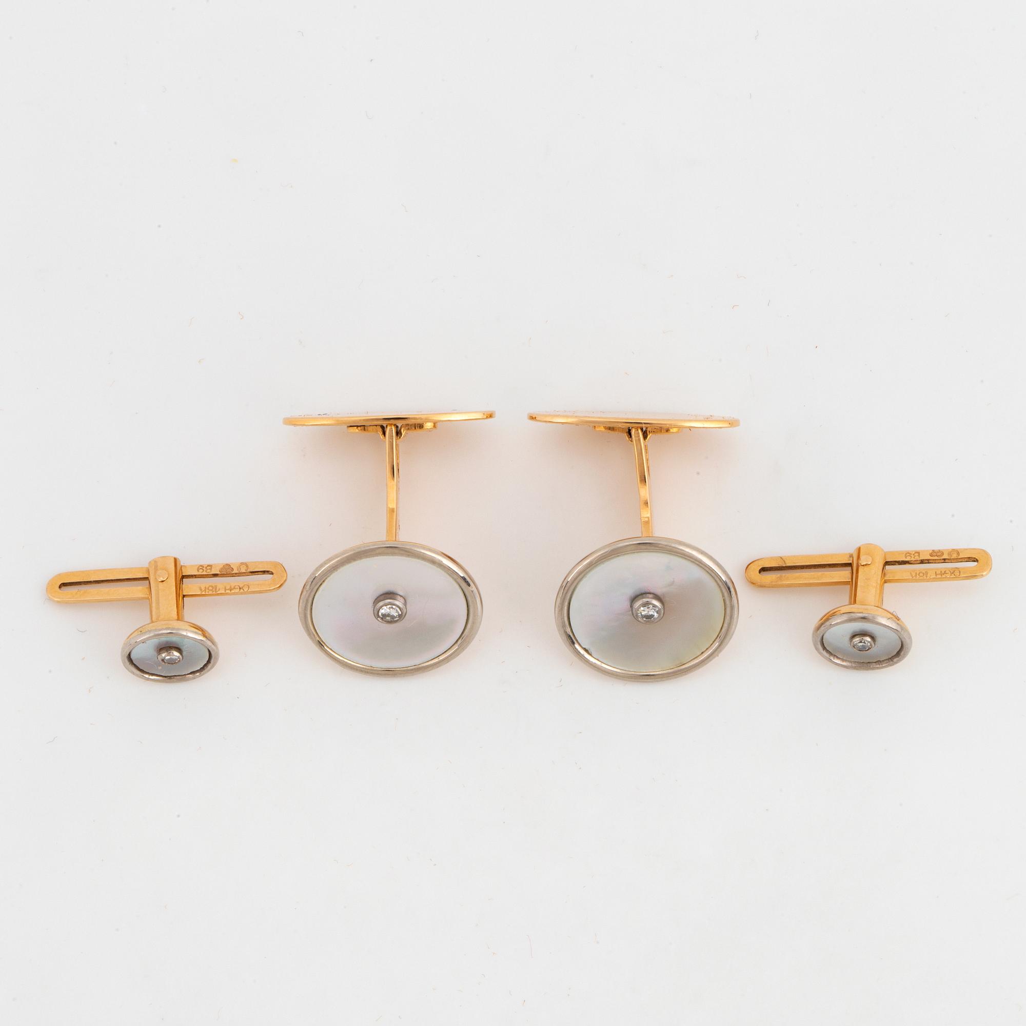 A pair of cufflinks and a pair of shirt buttons.