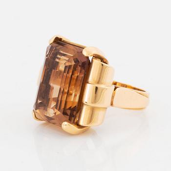 An 18K gold ring set with a step-cut citrine.