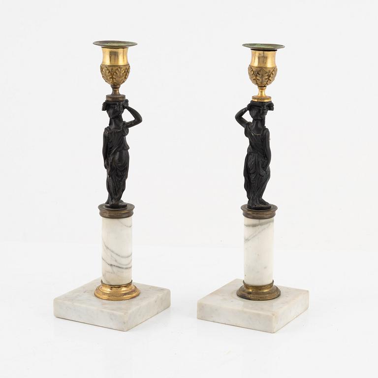 A pair of Gustavian-style ormolu, patinated bronze and marble candelsticks, circa 1900 incorporating older elements.