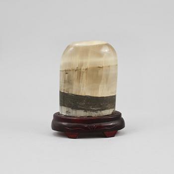 STEN, på träsockel.