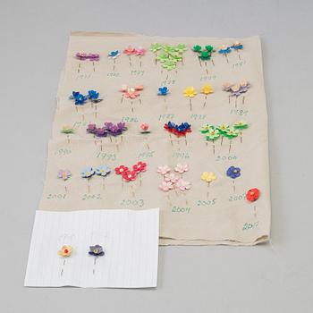 A collection of Swedish "Majblomman" brooches from between the years 1915-2016.