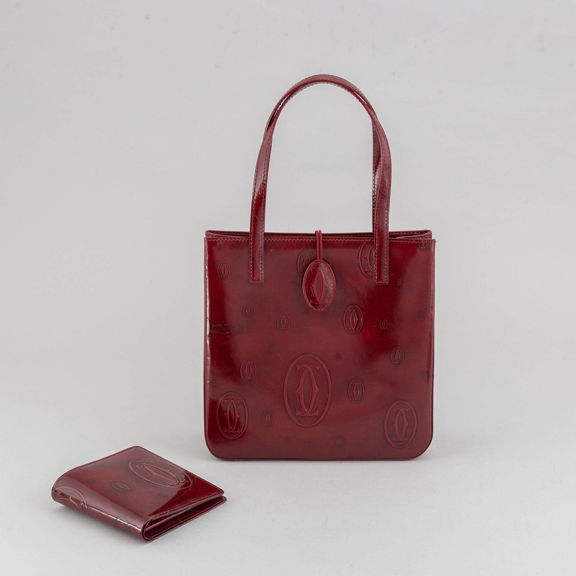 Cartier, a burgundy patent leather handbag and wallet.