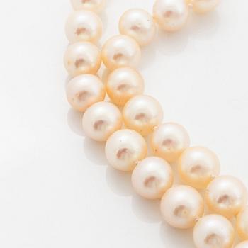 A two strand cultured pearl necklace with an 18K white gold and emerald clasp.