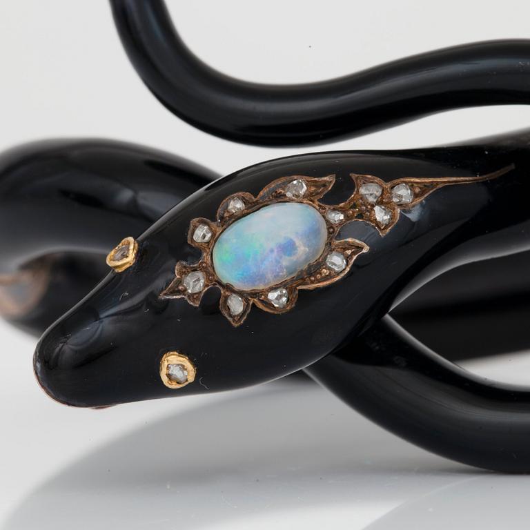 A Victorian snake bracelet in black enamel set with an opal and rose-cut diamonds.