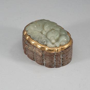 A partly gilded metal box with cover, mounted with a carved pale celadon nephrite plaque. Late Qing dynasty (1644-1912).