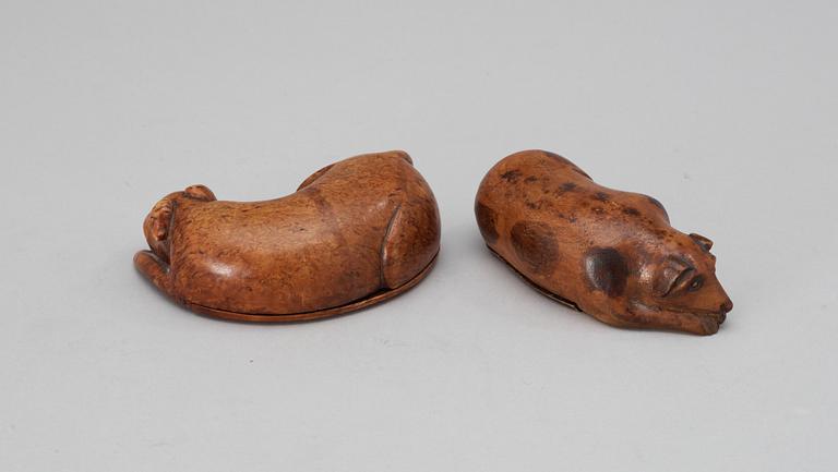 Two 19th-20th century birch snuffboxes in the shape of lying dogs.