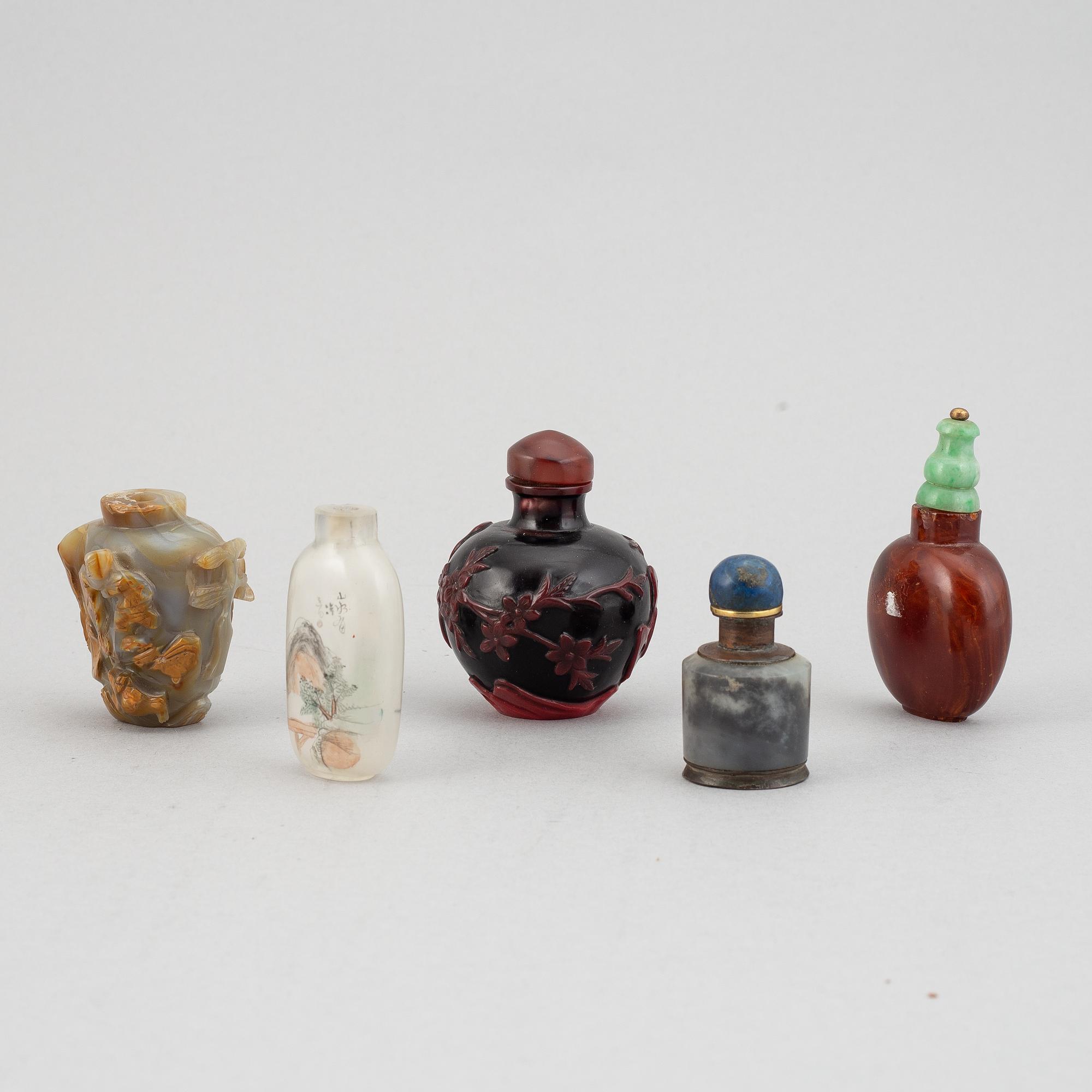 Five Chinese snuff bottles of different materials including stone and glass, 20th century.