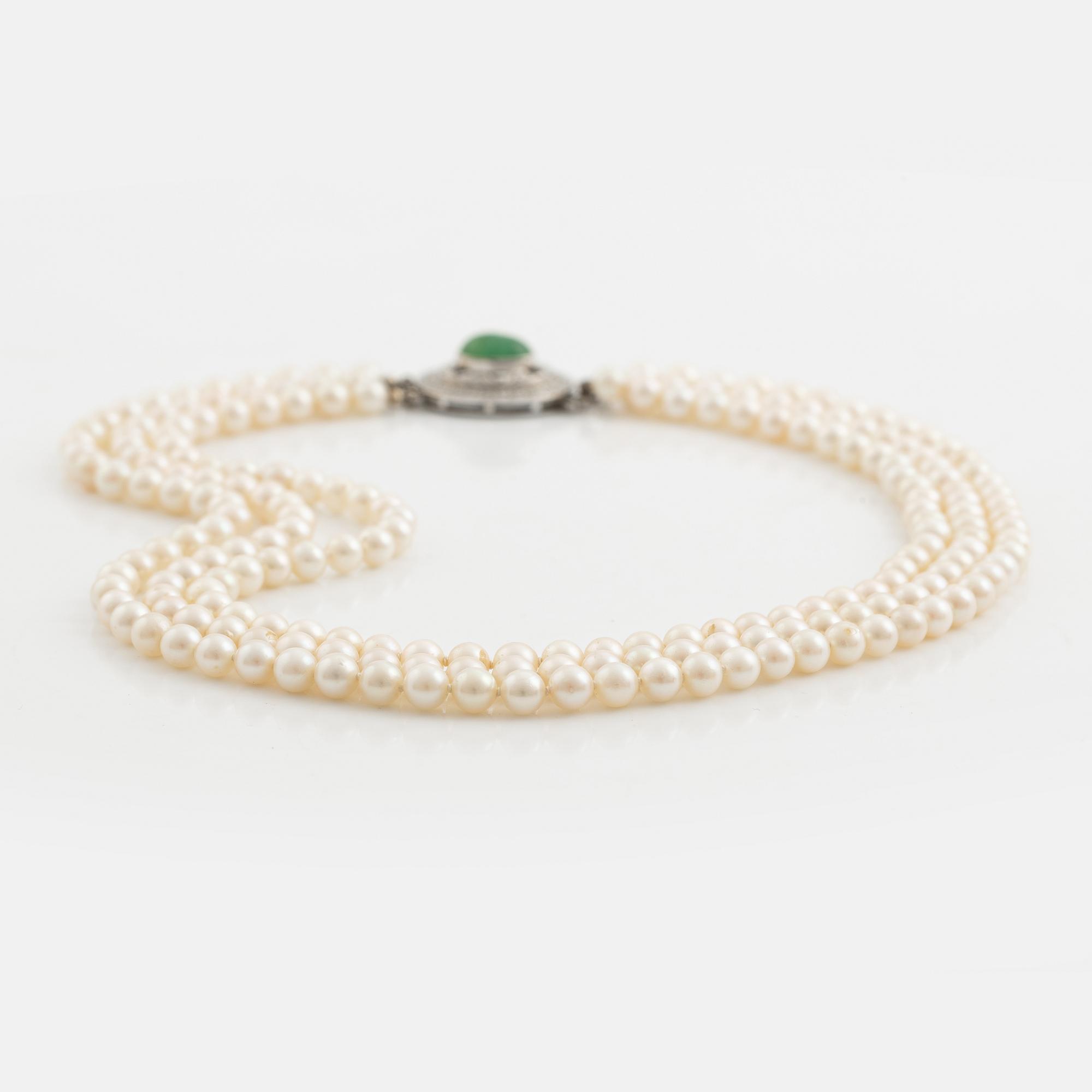 Three-row pearl necklace with cultured pearls, clasp with cabochon-cut emerald and brilliant-cut diamonds.