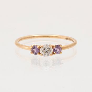 Ring "Edith" 18K guld med en rund briljantslipad diamant samt två rosa/lila safirer, Mumbaistockholm, Stockholm 2023.