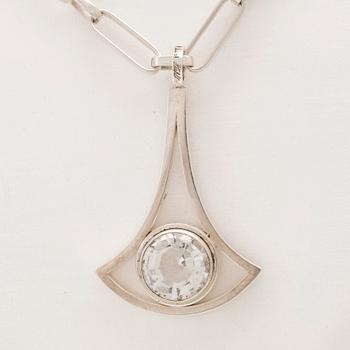 A silver necklace set with a round faceted rock quartz crystal by Göran Kuhlin Gothenburg 1971.