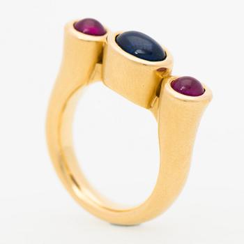 A RING, cabochon cut sapphire, cabochon cut rubies, 18K gold.