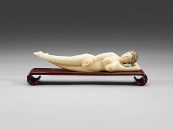 A ivory figure of a reclining 'Doctors Lady' on a wooden stand, Qing dynasty, circa 1900.
