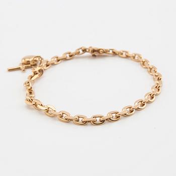 Bracelet with rounded anchor link in 18K gold with charms.