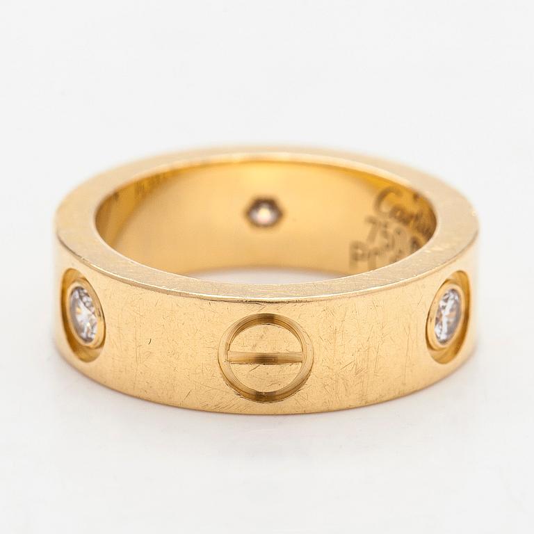 Cartier, an 18K gold 'Love' ring with three brilliant-cut diamonds.