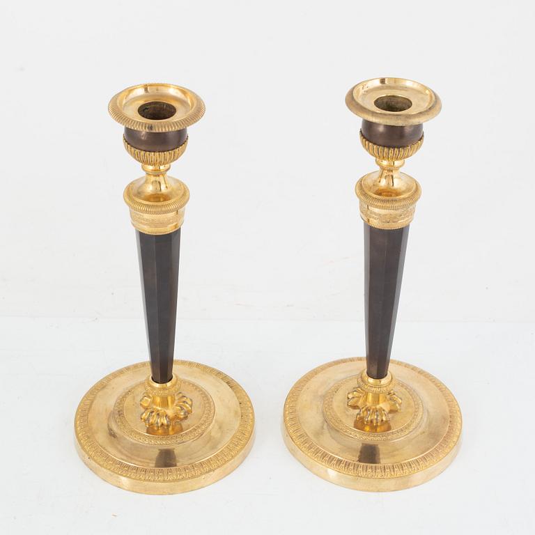 A pair of French gilt and patinated bronze Empire candlesticks, early 19th century.