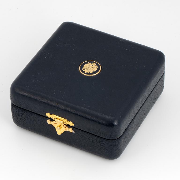 FABERGÉ-ÄGG, 18K guld med blå emalj och runda briljantslipade diamanter, med kedja, med etui.