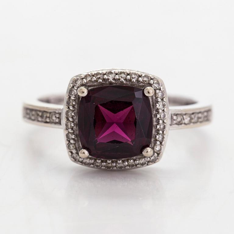 A 14K gold ring, with diamonds totalling approximately 0.095 ct and a garnet.