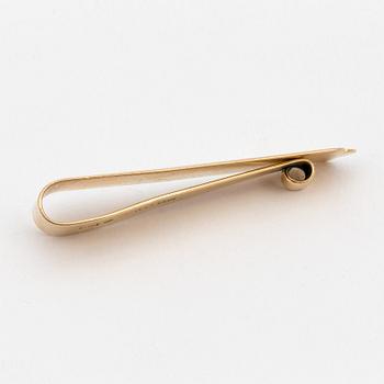 An 18K gold tie-clip.