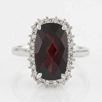 Ring in 18K gold with a checker-cut garnet and round brilliant-cut diamonds.