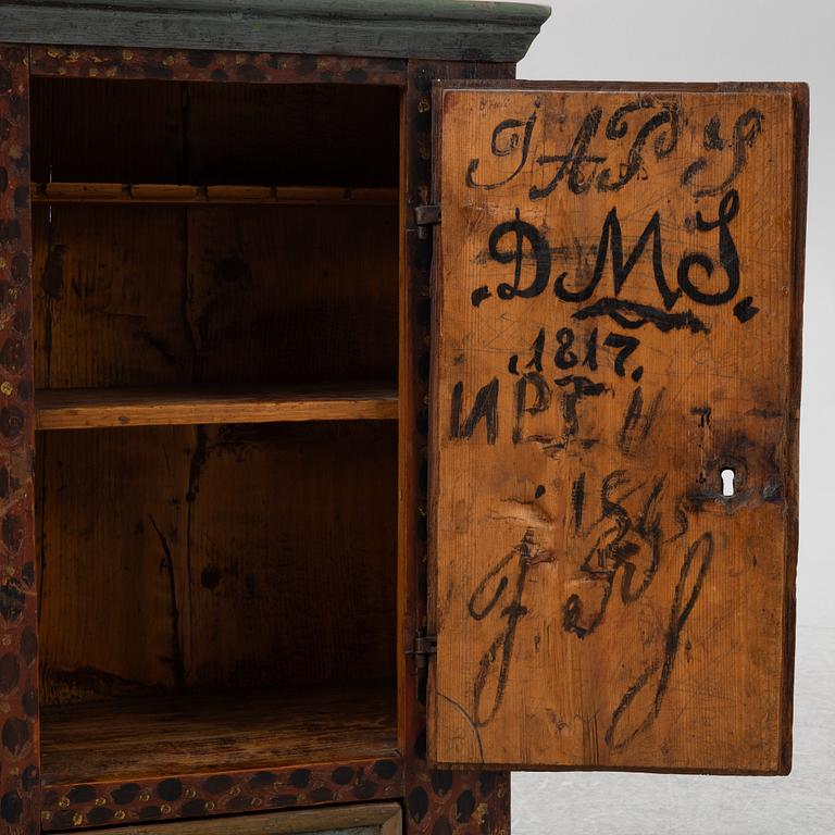 A painted wall cabinet, dated 1817.