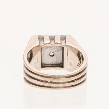A 21K white gold ring with round briliant cut diamonds.