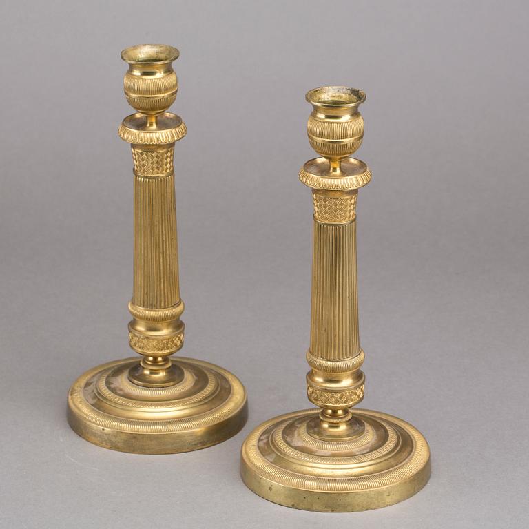 A pair of gilded bronze empire candlesticks, first half of the 19th century.