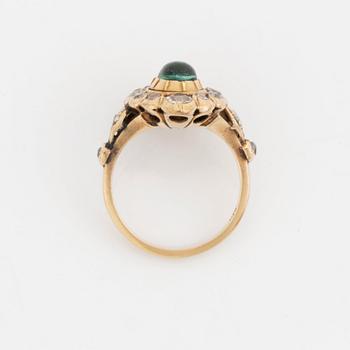 A 14K gold ring set with a cabochon-cut emerald and old-cut diamonds.