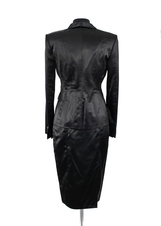 A two-piece black silk costume consisting of jacket and skirt by Gucci.