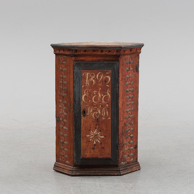 A Swedish painted corner cabinet, dated 1825.
